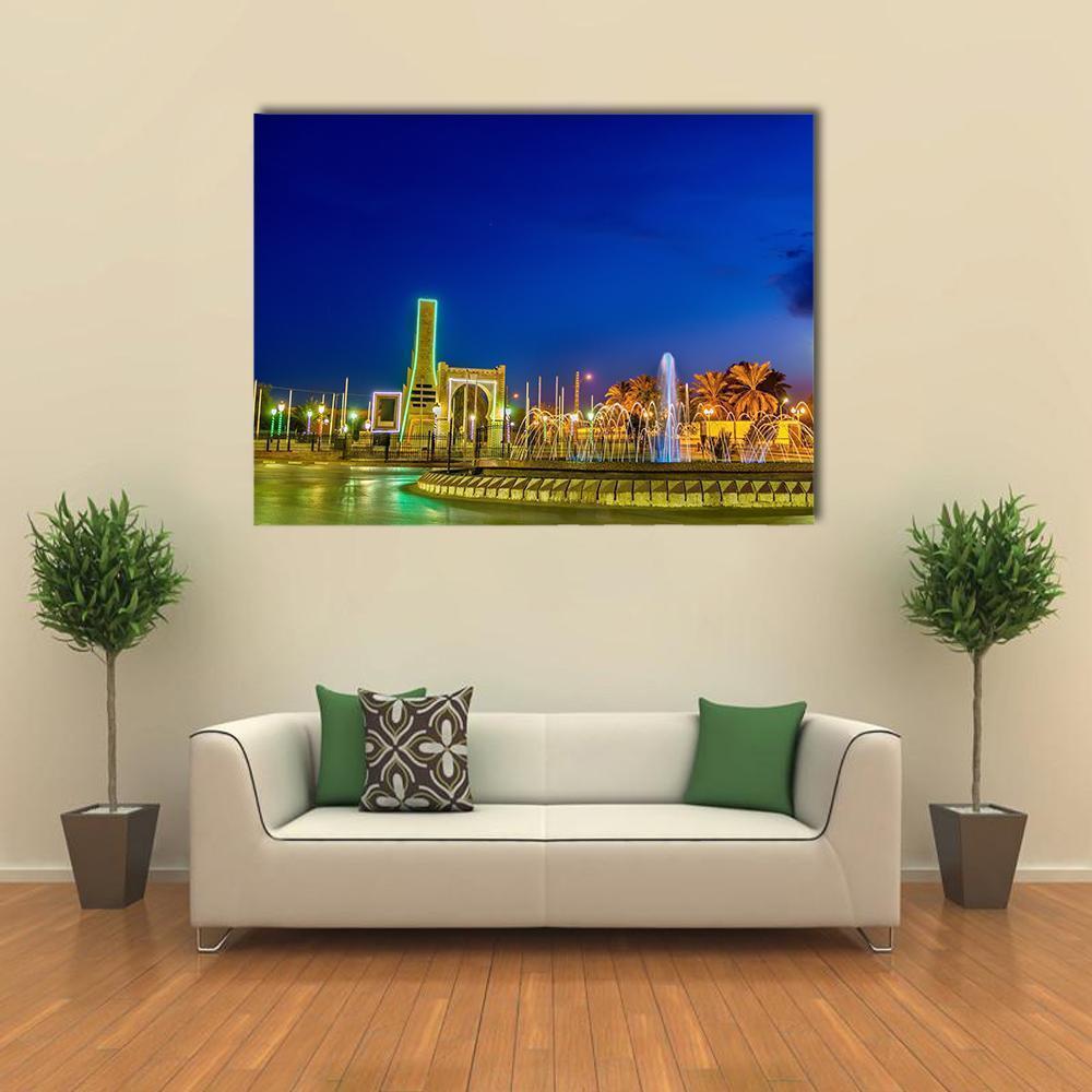 Night Fountain with Arched Gateway Canvas Wall Art in yellow, green and blue, single panel hung on a wall