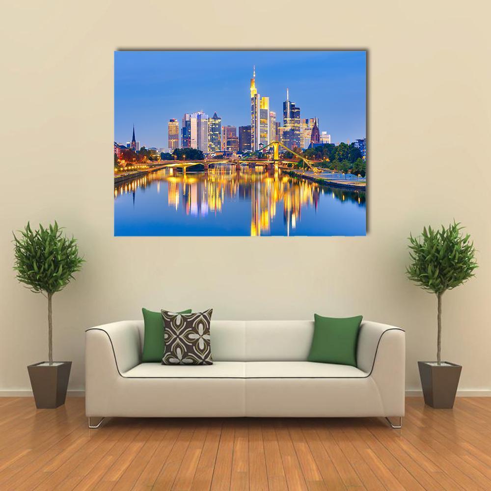 Dusk City Skyline with River Reflections Canvas Wall Art in orange, yellow and blue, single panel hung on a wall