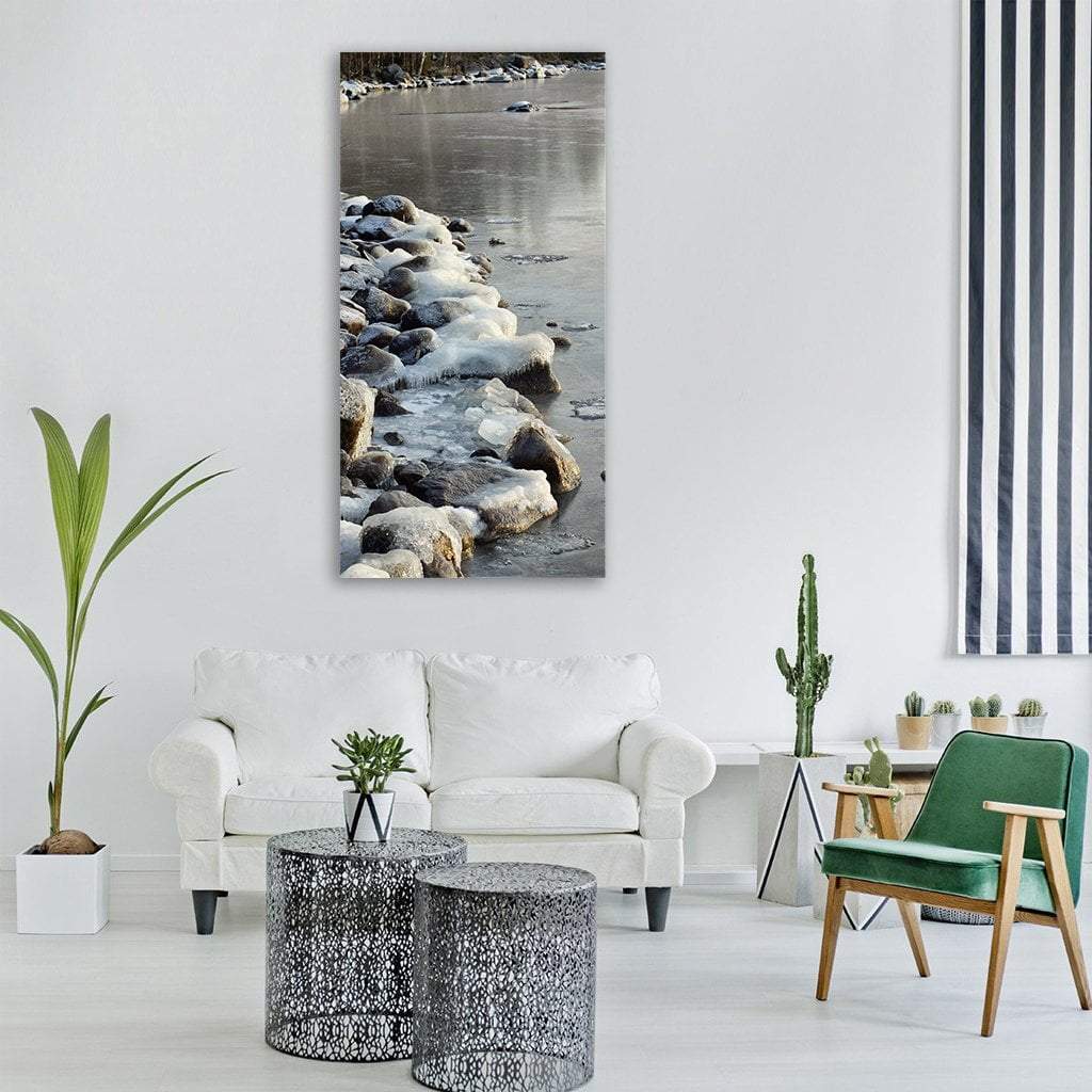 Ice-covered Rocks on Frozen Shoreline Vertical Canvas Wall Art in white and gray, single vertical panel hung on a wall