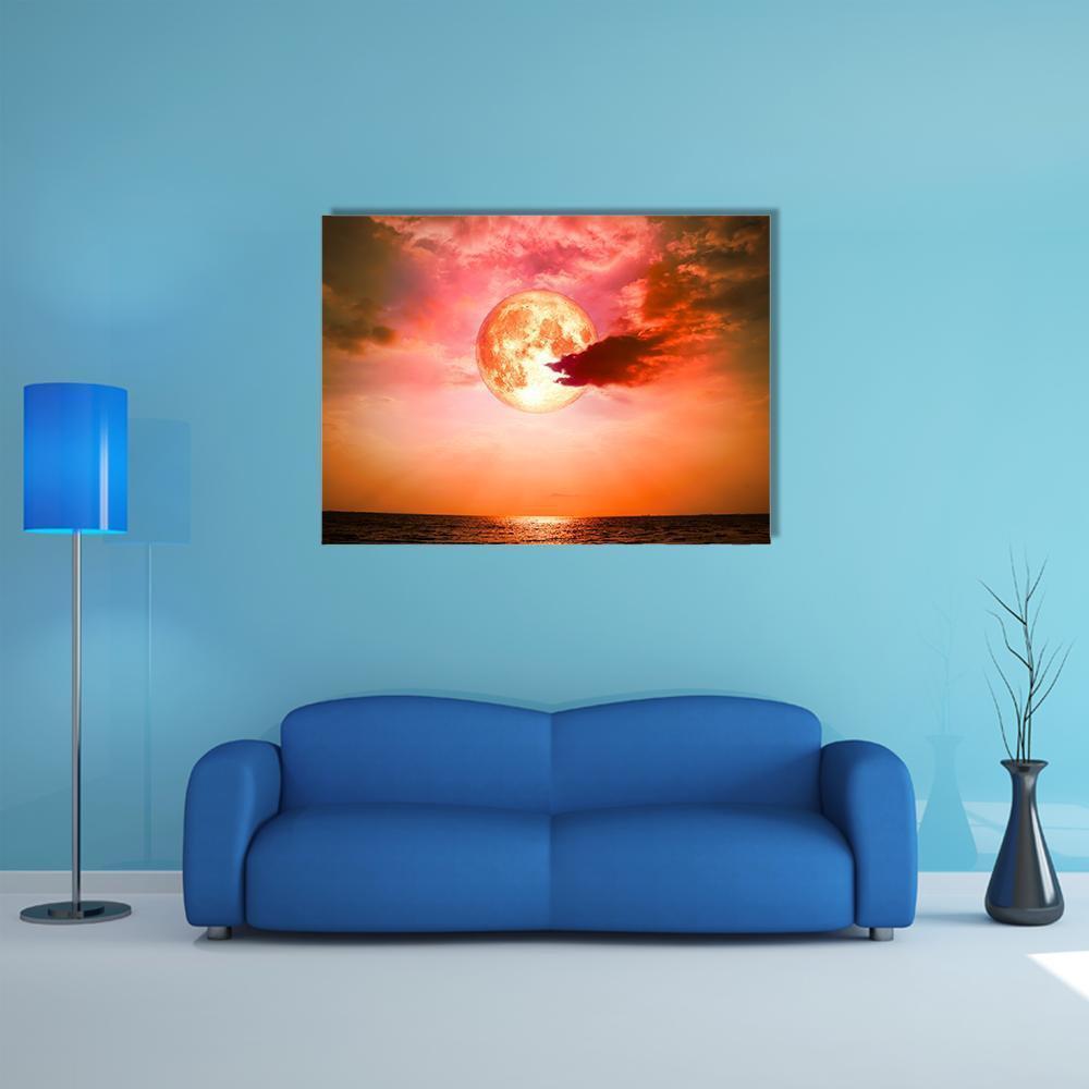 Full Blood Moon Over Ocean Canvas Wall Art in red, orange and pink, single panel hung on a wall