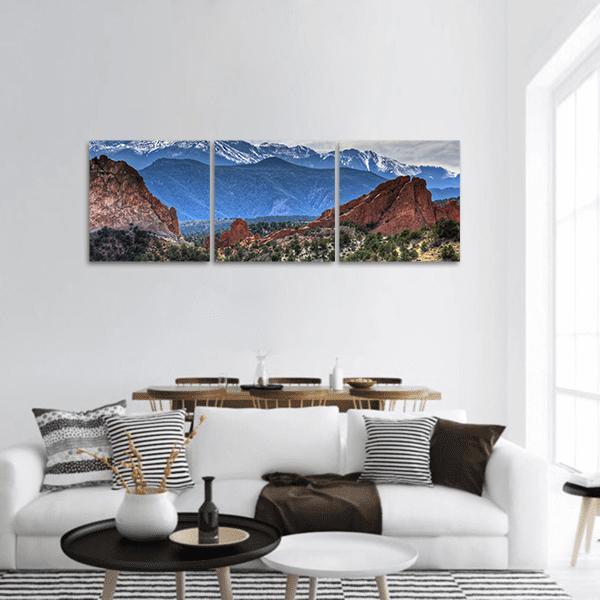 Red Sandstone and Snow-capped Mountain Vista Panoramic Canvas Wall Art in brown, red and blue, hung on a wall