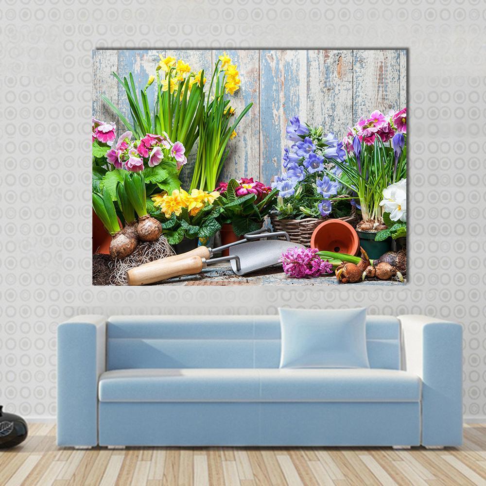 Gardener Planting Spring Flowers Canvas Wall Art in yellow, green and blue, single panel hung on a wall