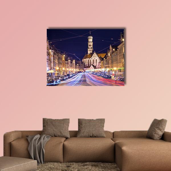 German Night Street with Tower and Light Trails Canvas Wall Art in black, yellow and blue, single panel hung on a wall