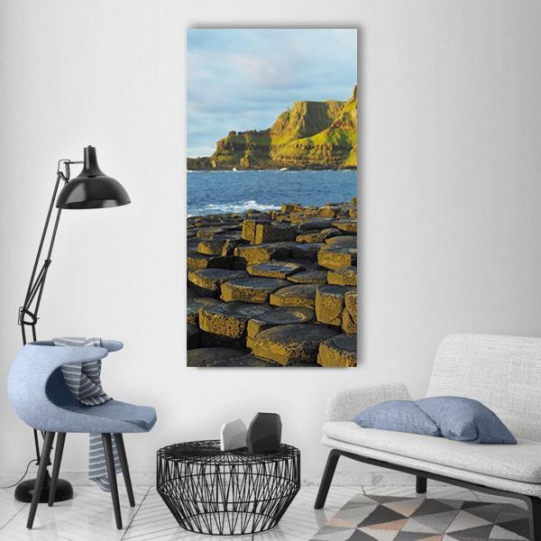Giant's Causeway Basalt Columns Vertical Canvas Wall Art in gray, brown and blue, single vertical panel hung on a wall