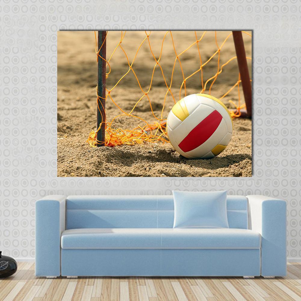 Tri-color Volleyball on Beach Sand Canvas Wall Art in beige, orange and yellow, single panel hung on a wall