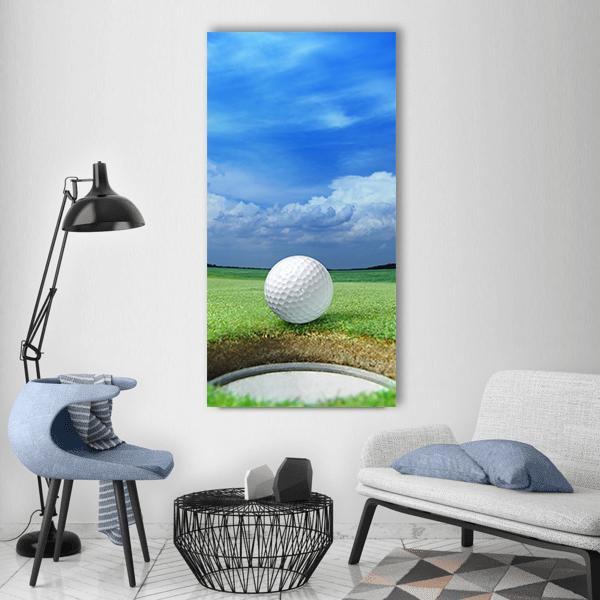 Close-up Golf Ball on Putting Green Vertical Canvas Wall Art in white, green and blue, single vertical panel hung on a wall