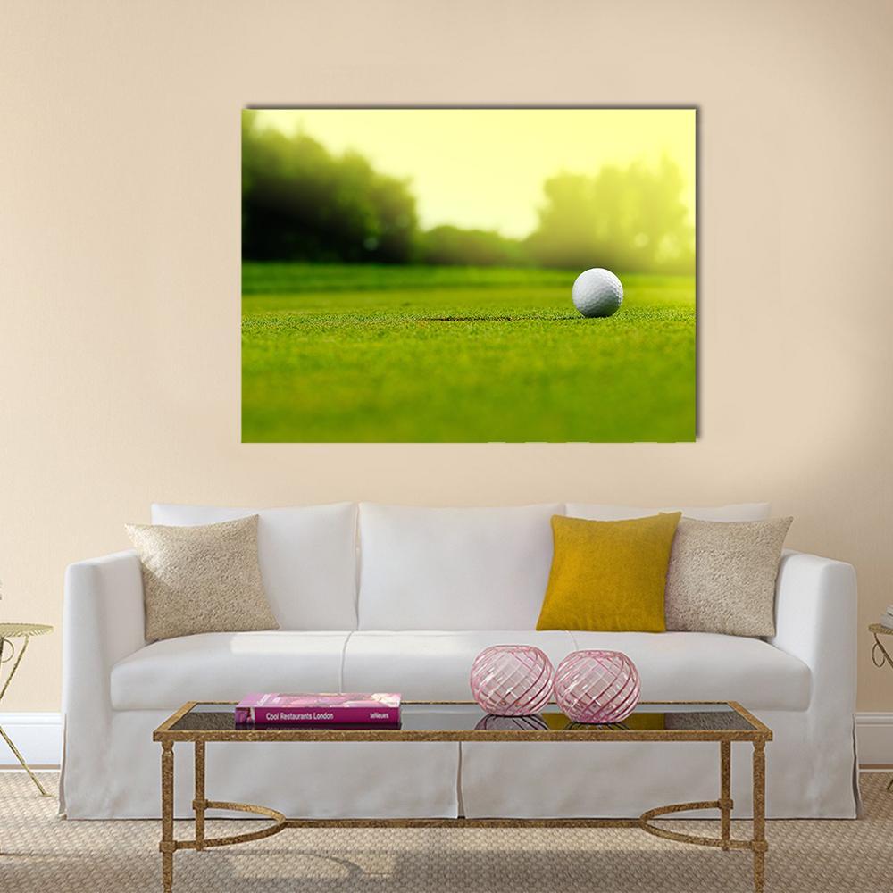 Golf Ball in the Hole Canvas Wall Art in white, yellow and green, single panel hung on a wall