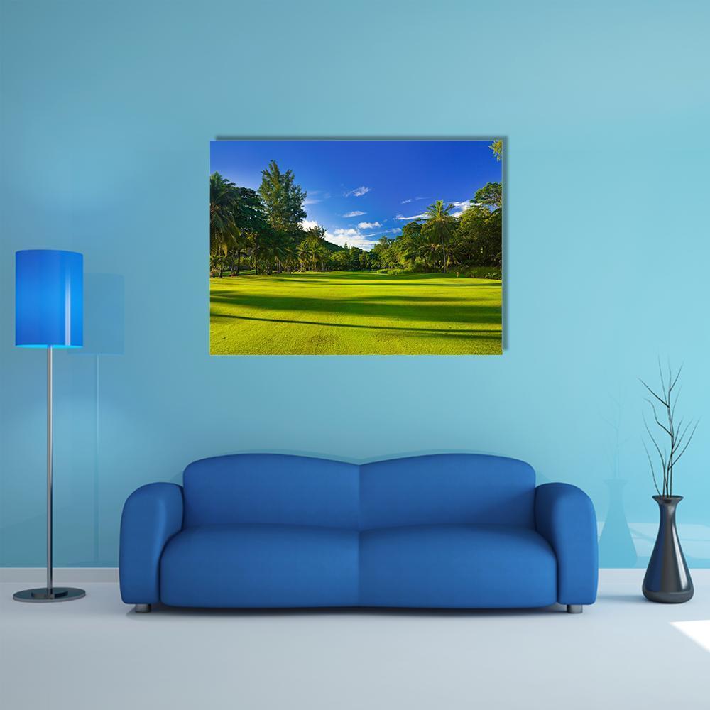 Sunlit Golf Course with Palm Trees Canvas Wall Art in green and blue, single panel hung on a wall
