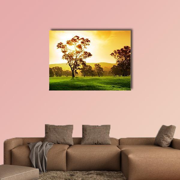 Sunlit Rural Field at Sunset Canvas Wall Art in orange, yellow and green, single panel hung on a wall