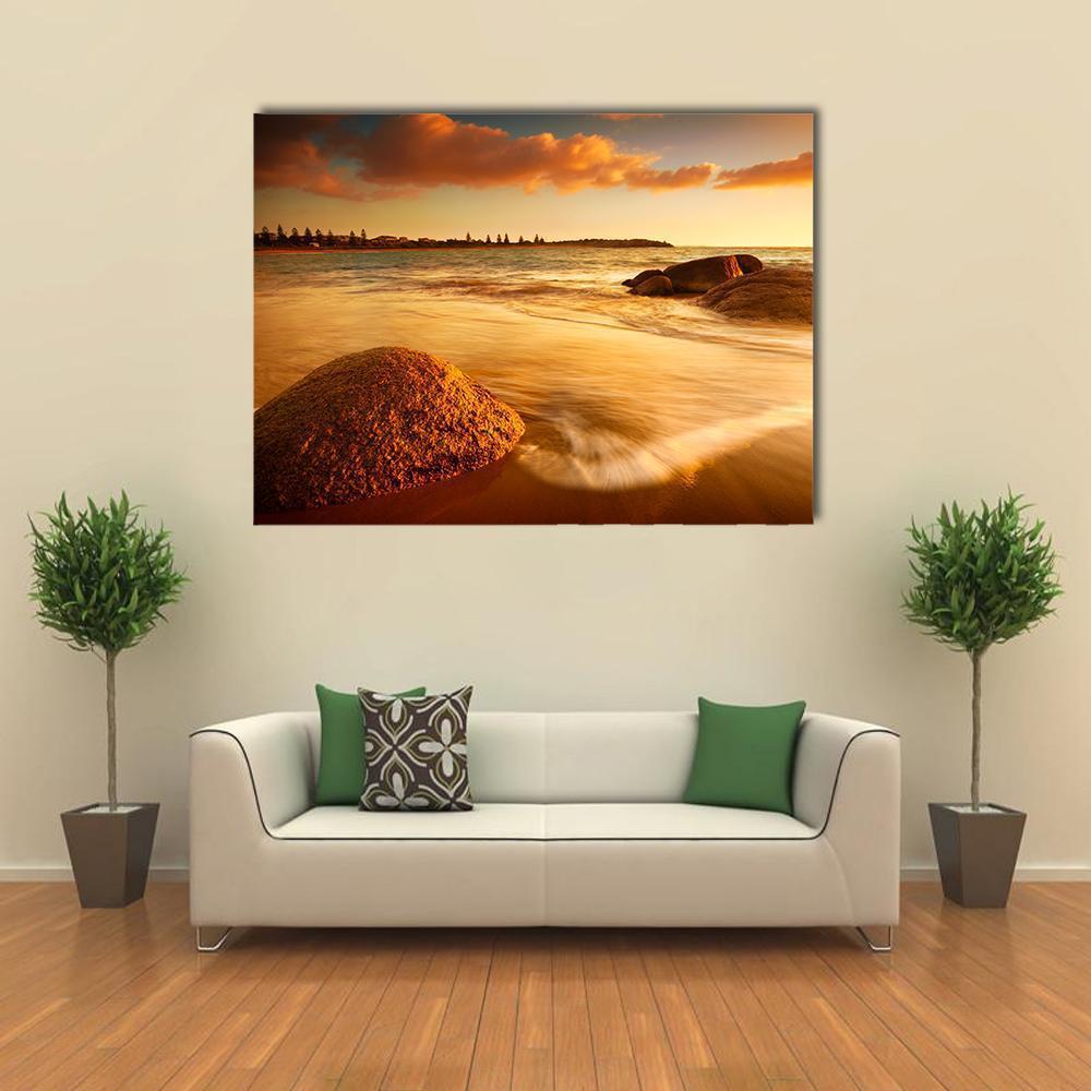 Sunrise Over Australian Beach Canvas Wall Art in brown, orange and yellow, single panel hung on a wall