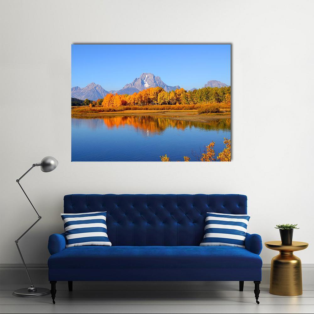 Snow-capped Mountains with Autumn Lake Reflection Canvas Wall Art in orange, yellow and blue, single panel hung on a wall