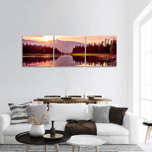 Grand Teton Sunrise Over Jackson Lake Panoramic Canvas Wall Art in orange, purple and pink, hung on a wall