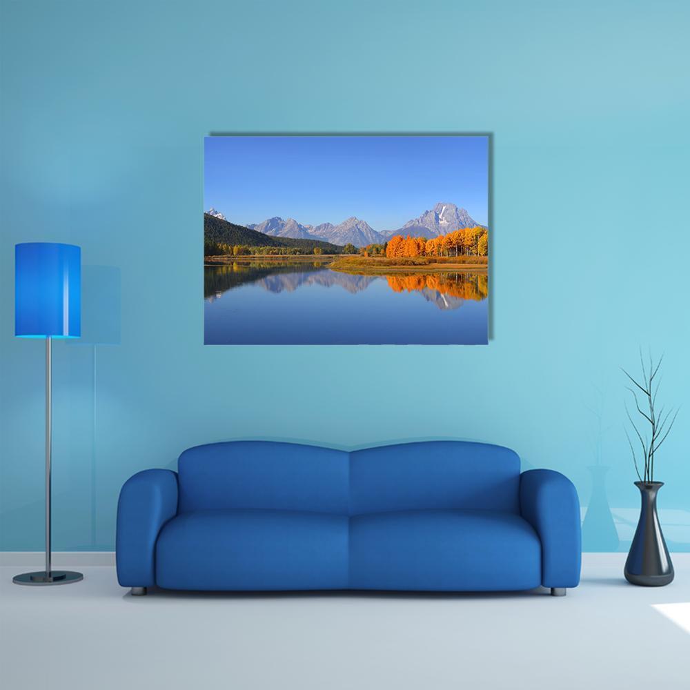 Grand Tetons Autumn Lake Reflection Canvas Wall Art in orange, yellow and blue, single panel hung on a wall