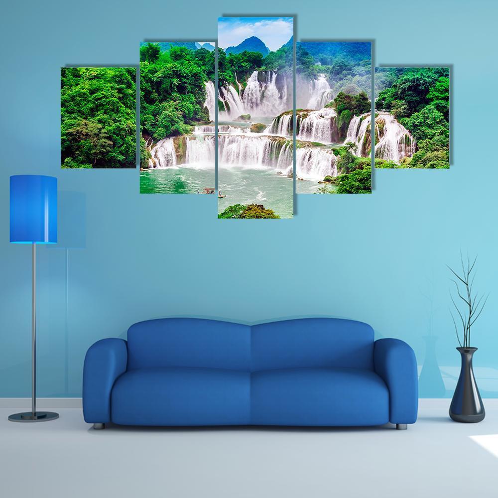 Tiered Waterfall in Lush Green Forest Canvas Wall Art in white, green and blue, 5 panel Star layout hung on a wall
