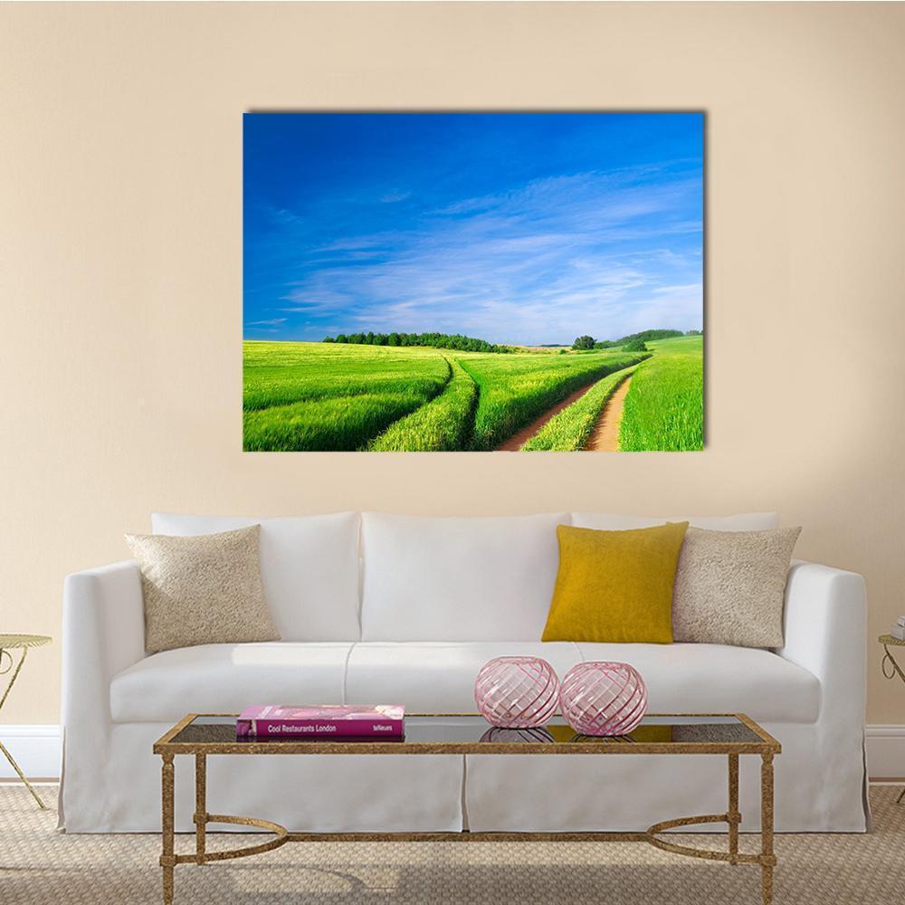 Winding Path Through Green Fields Canvas Wall Art in green and blue, single panel hung on a wall