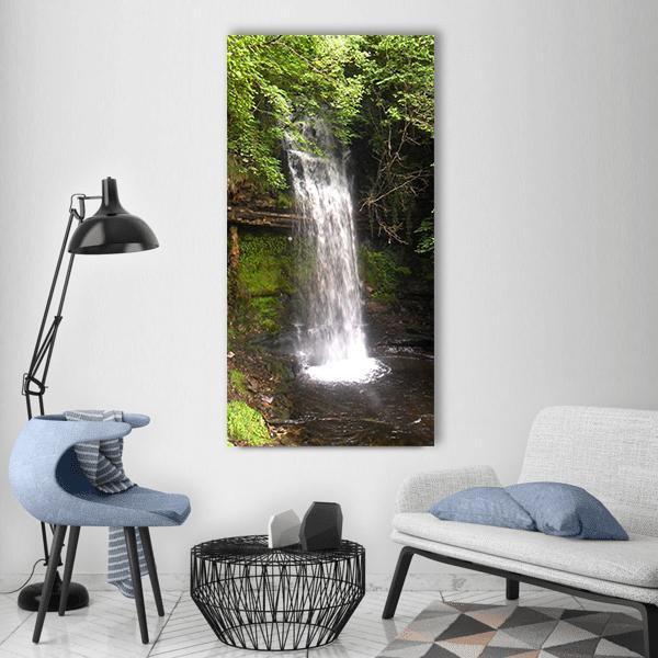 Lush Green Forest Waterfall Vertical Canvas Wall Art in white, brown and green, single vertical panel hung on a wall