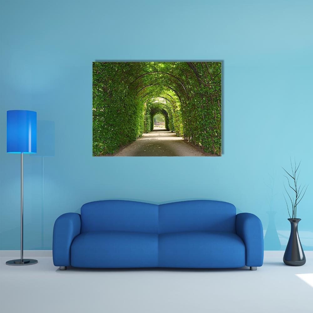 Green Tunnel of Trees Canvas Wall Art in brown and green, single panel hung on a wall