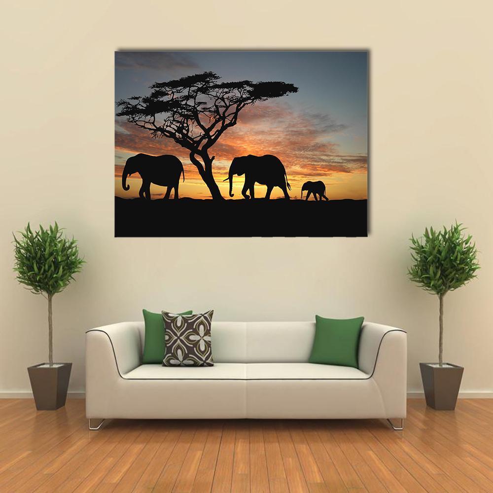 Herd of Elephants at Sunset Canvas Wall Art in black, orange and blue, single panel hung on a wall