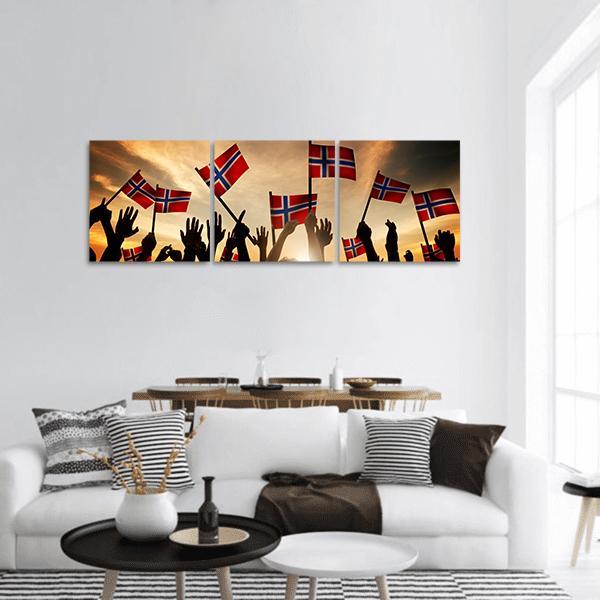 Crowd Waving Norwegian Flags at Sunset Panoramic Canvas Wall Art in black, red and orange, hung on a wall