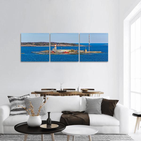 Small Island Lighthouse with Communications Tower Panoramic Canvas Wall Art in white and blue, hung on a wall