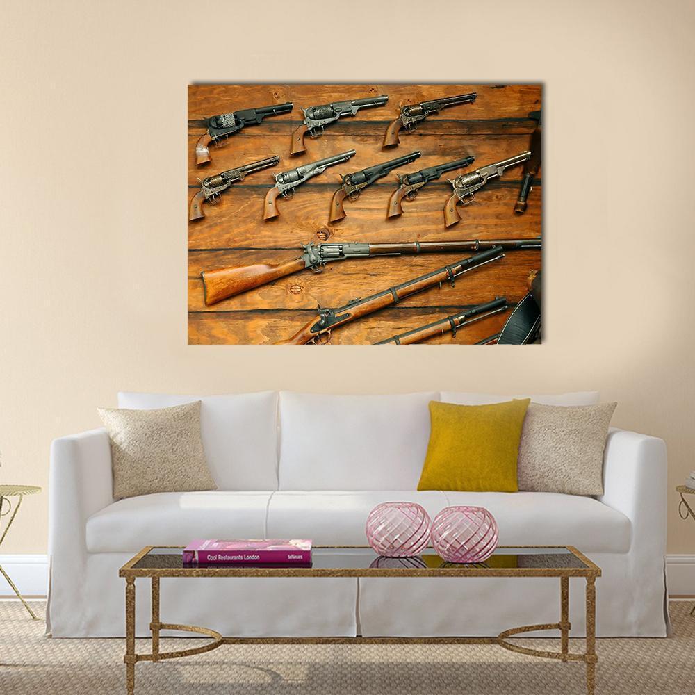 Vintage Collection of Revolvers and Rifles Canvas Wall Art in black, gray and brown, single panel hung on a wall