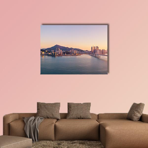 Aerial City Bridge at Sunset Canvas Wall Art in orange, blue and purple, single panel hung on a wall