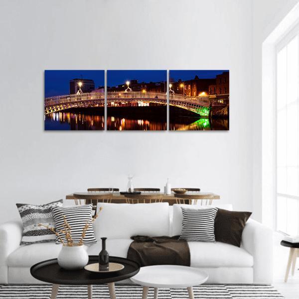 Ha'penny Bridge at Night Panoramic Canvas Wall Art in black, orange and blue, hung on a wall