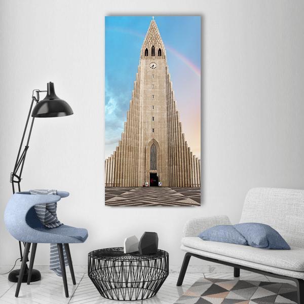 Hallgrimskirkja Cathedral with Rainbow Vertical Canvas Wall Art in gray, beige and blue, single vertical panel hung on a wall