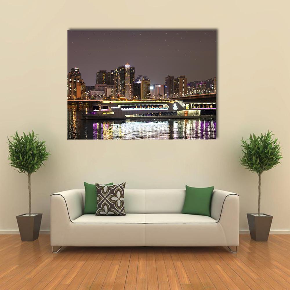 Night City Skyline with Bridge Reflection Canvas Wall Art in black, gray and yellow, single panel hung on a wall