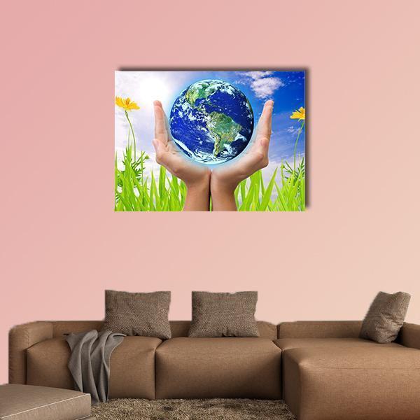 Hands Cradling the Earth Canvas Wall Art in white, green and blue, single panel hung on a wall