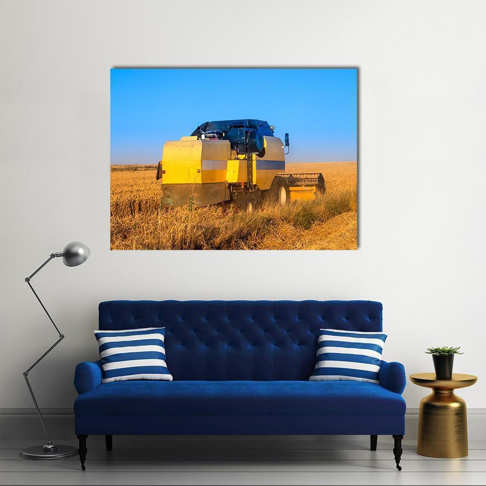Combine Harvester in Golden Wheat Field Canvas Wall Art in gold, yellow and blue, single panel hung on a wall