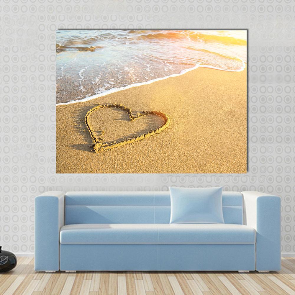Heart Drawn on Sand Canvas Wall Art in beige, yellow and blue, single panel hung on a wall