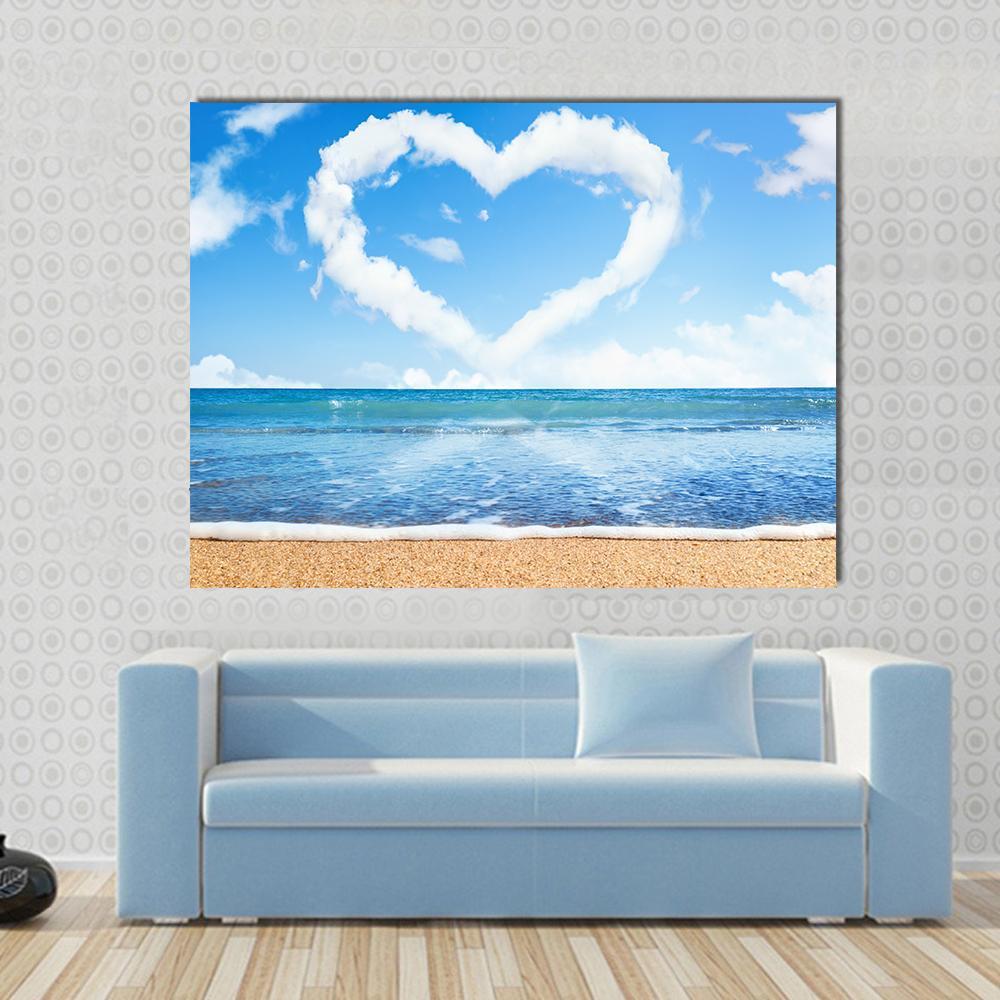 Heart-shaped Cloud Over Beach Canvas Wall Art in white and blue, single panel hung on a wall