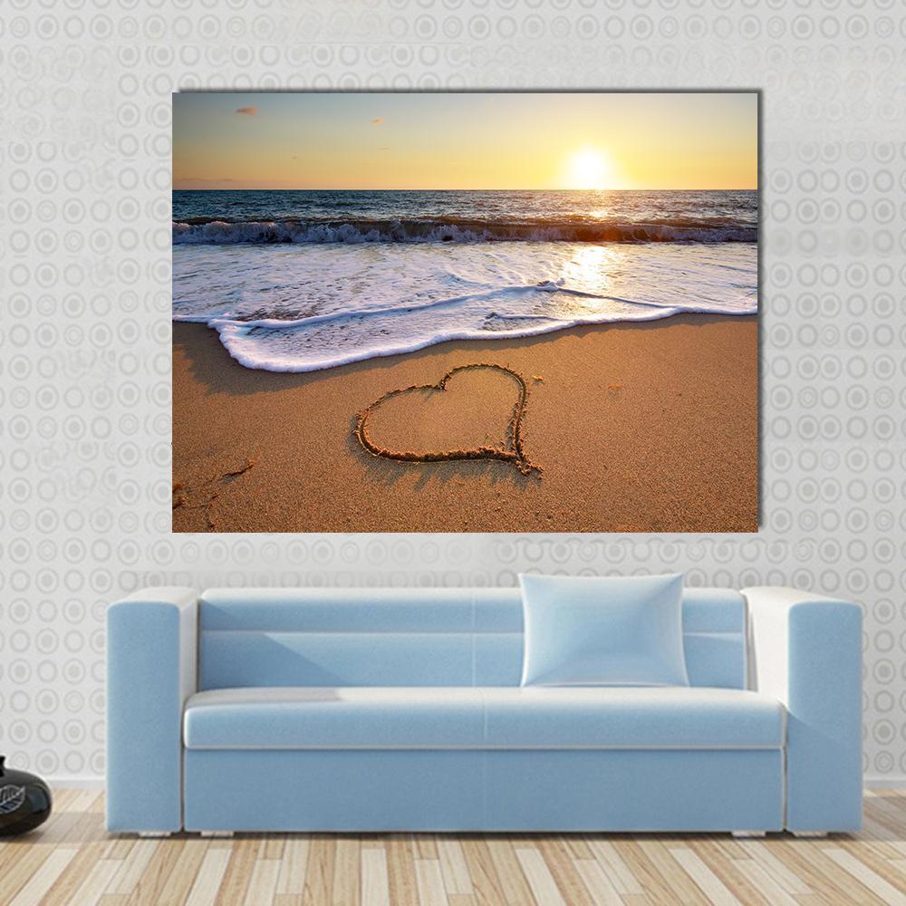 Heart on Beach Canvas Wall Art in beige, yellow and blue, single panel hung on a wall
