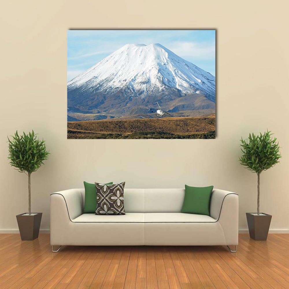 Helicopter Near Snow-capped Mountain Canvas Wall Art in white, brown and blue, single panel hung on a wall