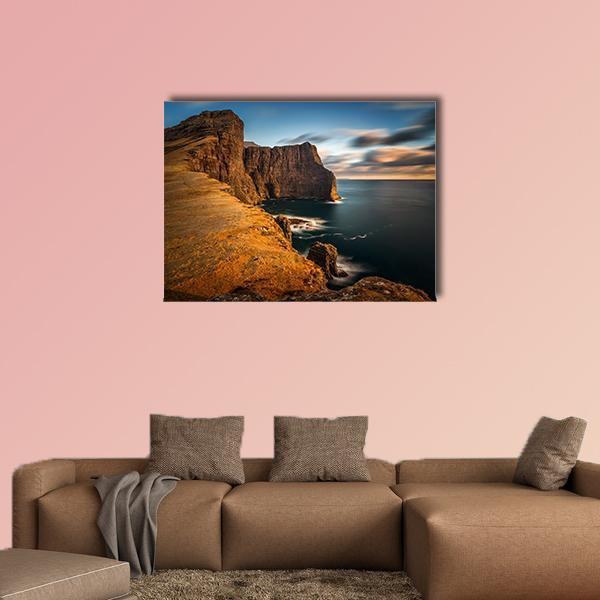 High Coastal Cliffs at Golden Hour Canvas Wall Art in brown, orange and blue, single panel hung on a wall