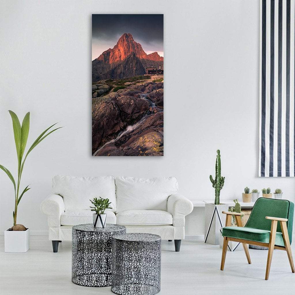 Mountain Cabin at Sunrise Vertical Canvas Wall Art in gray, brown and orange, single vertical panel hung on a wall