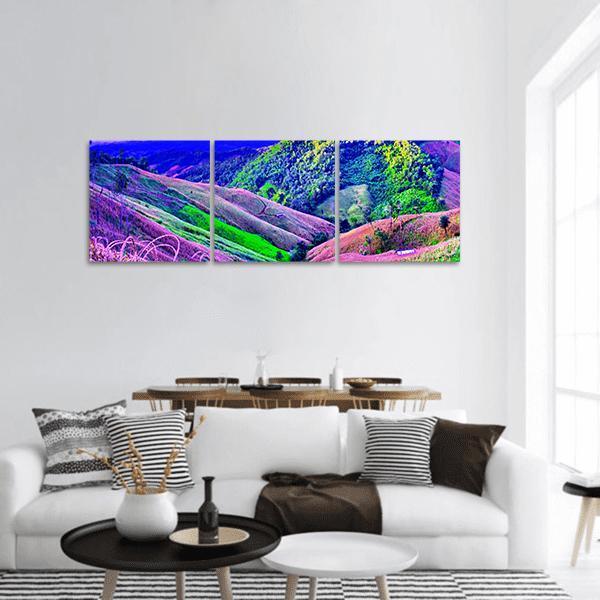 High Mountains and Terraced Fields Panoramic Canvas Wall Art in green, blue and purple, hung on a wall