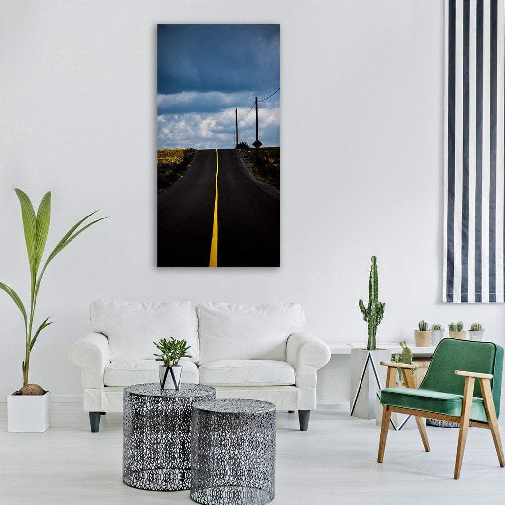Rural Highway Between Fields Vertical Canvas Wall Art in black, yellow and blue, single vertical panel hung on a wall