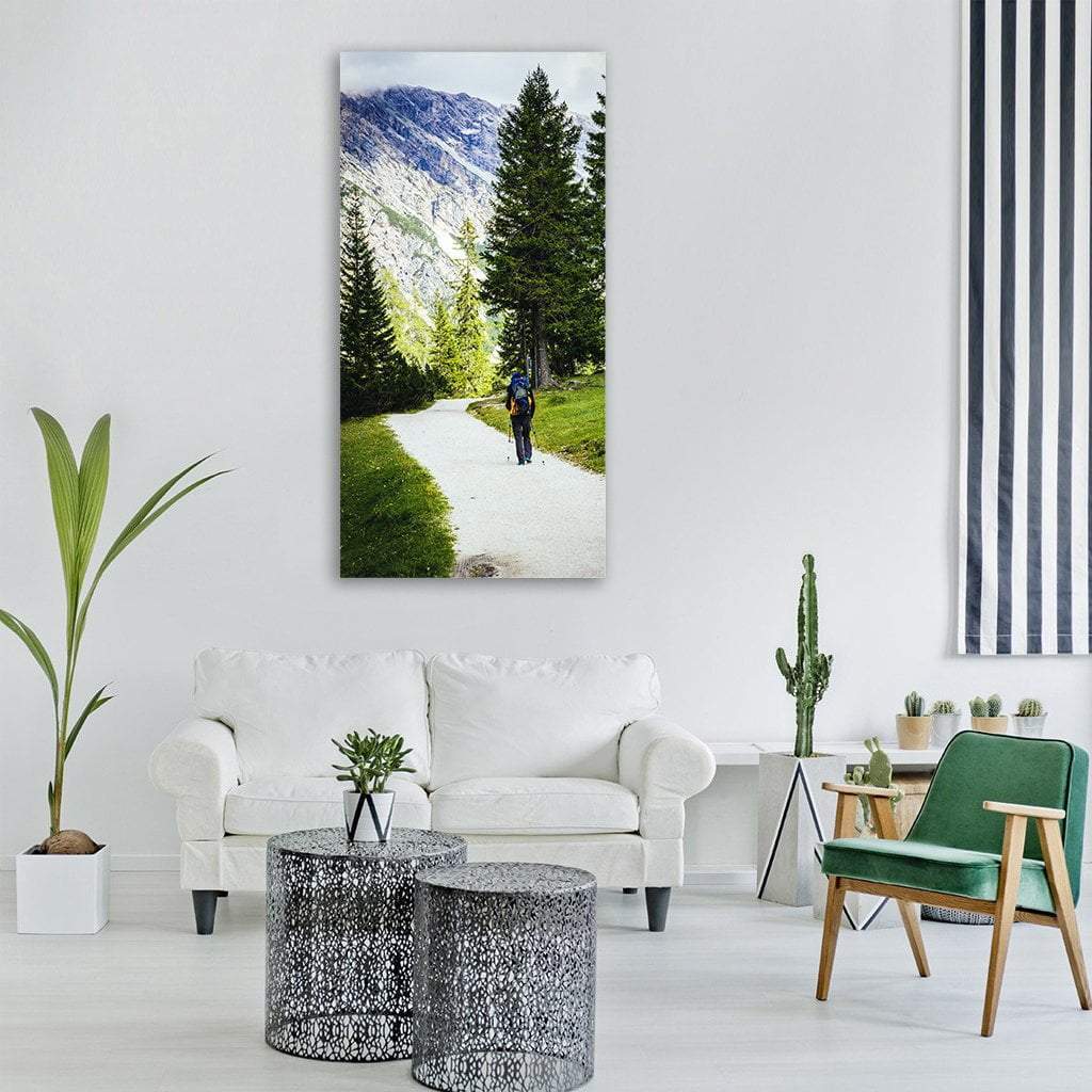 Hiker on Winding Mountain Path Vertical Canvas Wall Art in white, gray and green, single vertical panel hung on a wall