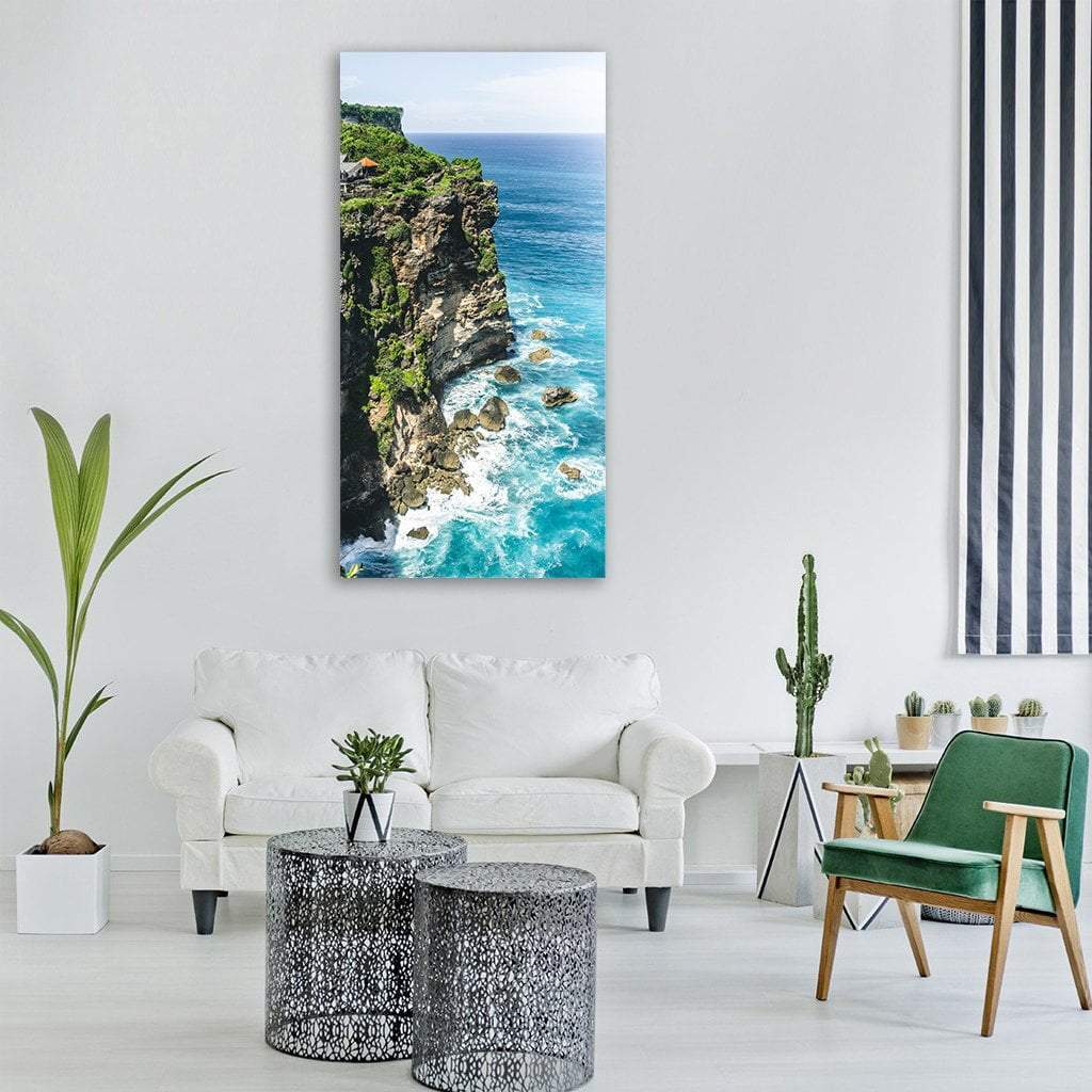 Lush Coastal Cliffs with Turquoise Waves Vertical Canvas Wall Art in brown, green and blue, single vertical panel hung on a wall