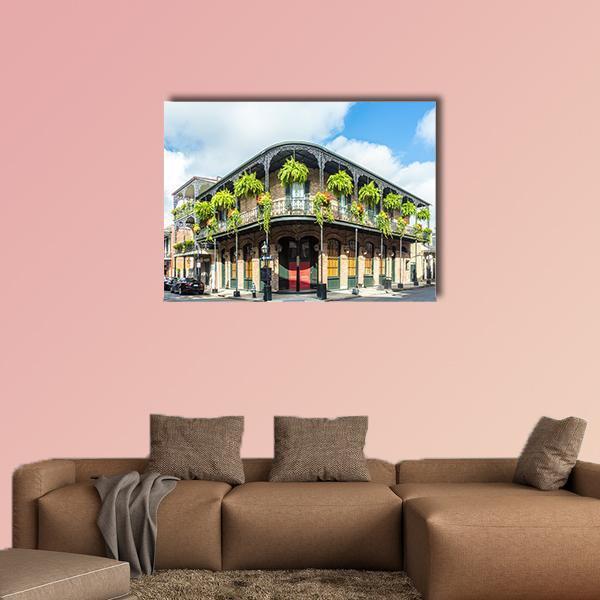 Historic Building with Wrought-iron Balconies and Red Door Canvas Wall Art in brown, green and blue, single panel hung on a wall