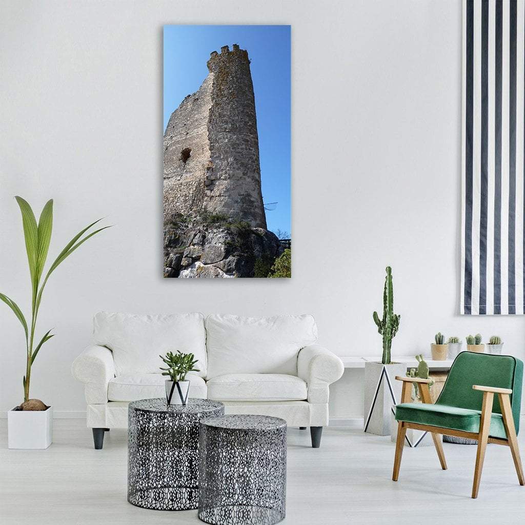 Crenellated Castle Ruins with Stone Tower Vertical Canvas Wall Art in gray, brown and blue, single vertical panel hung on a wall