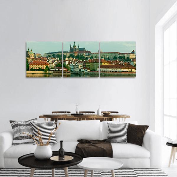 Prague Castle Over Vltava River Panoramic Canvas Wall Art in orange, green and blue, hung on a wall