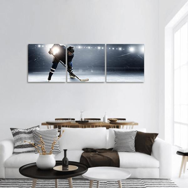 Hockey Player at Ice Rink Panoramic Canvas Wall Art in black, white and blue, hung on a wall