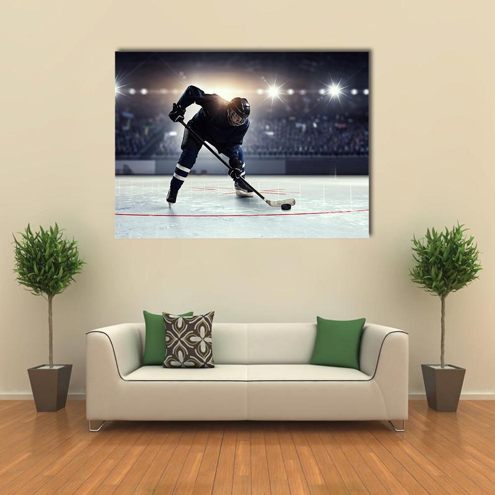 Dynamic Hockey Player on Ice Rink Canvas Wall Art in black, white and blue, single panel hung on a wall