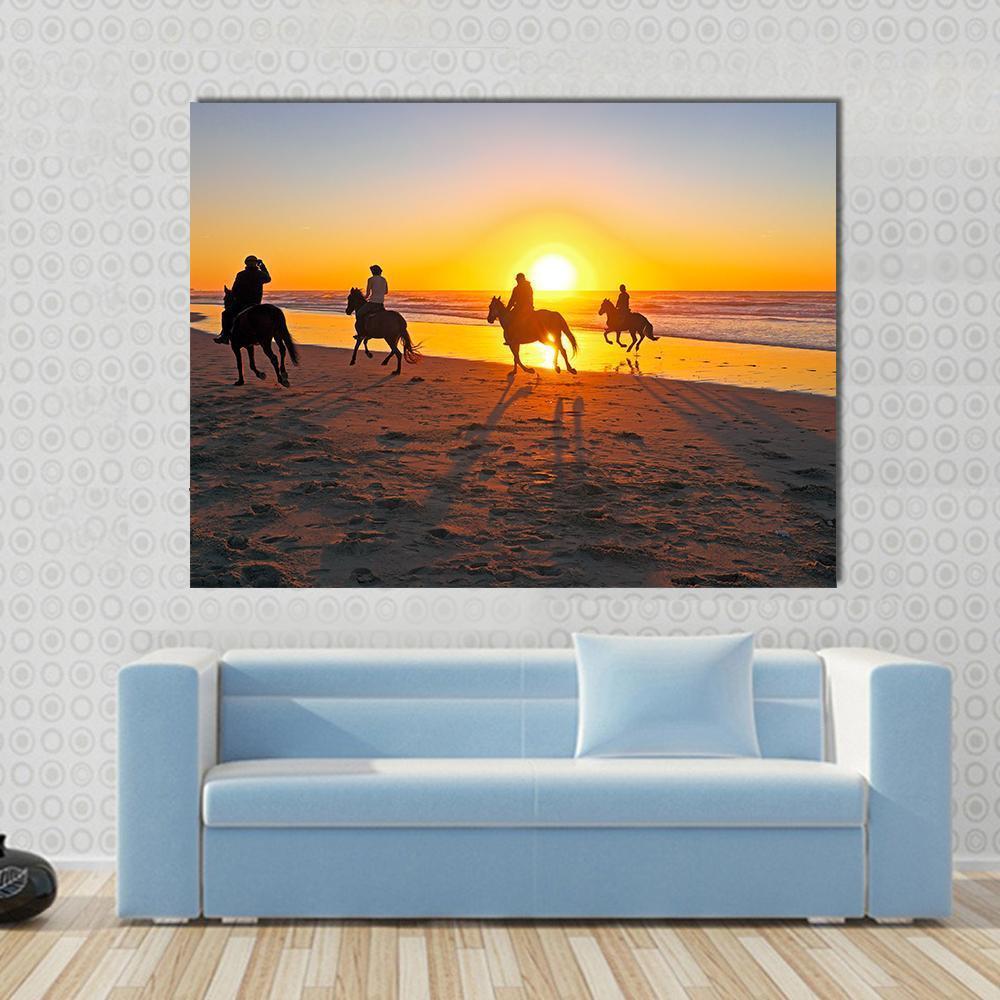 Horse Riding on Beach at Sunset Canvas Wall Art in orange, yellow and blue, single panel hung on a wall