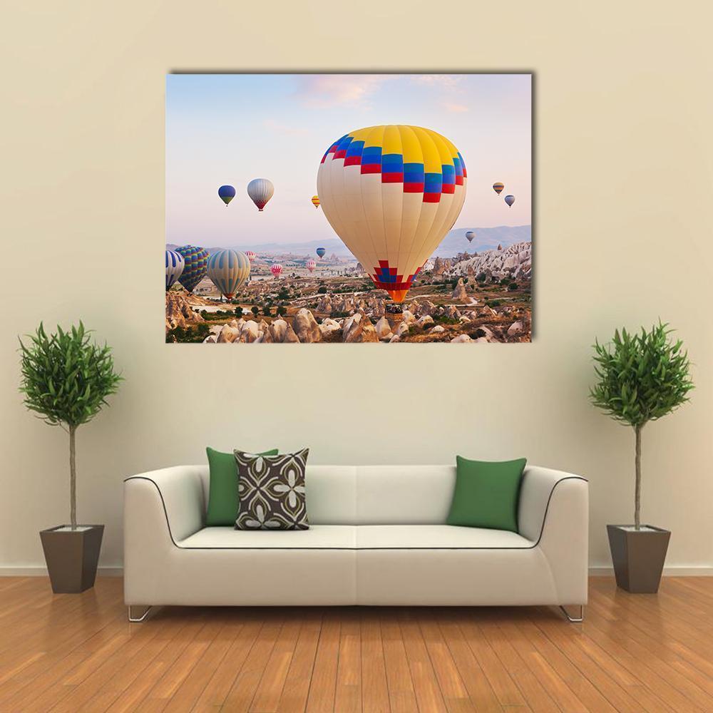 Hot Air Balloons Over Cappadocia Canvas Wall Art in beige, yellow and blue, single panel hung on a wall
