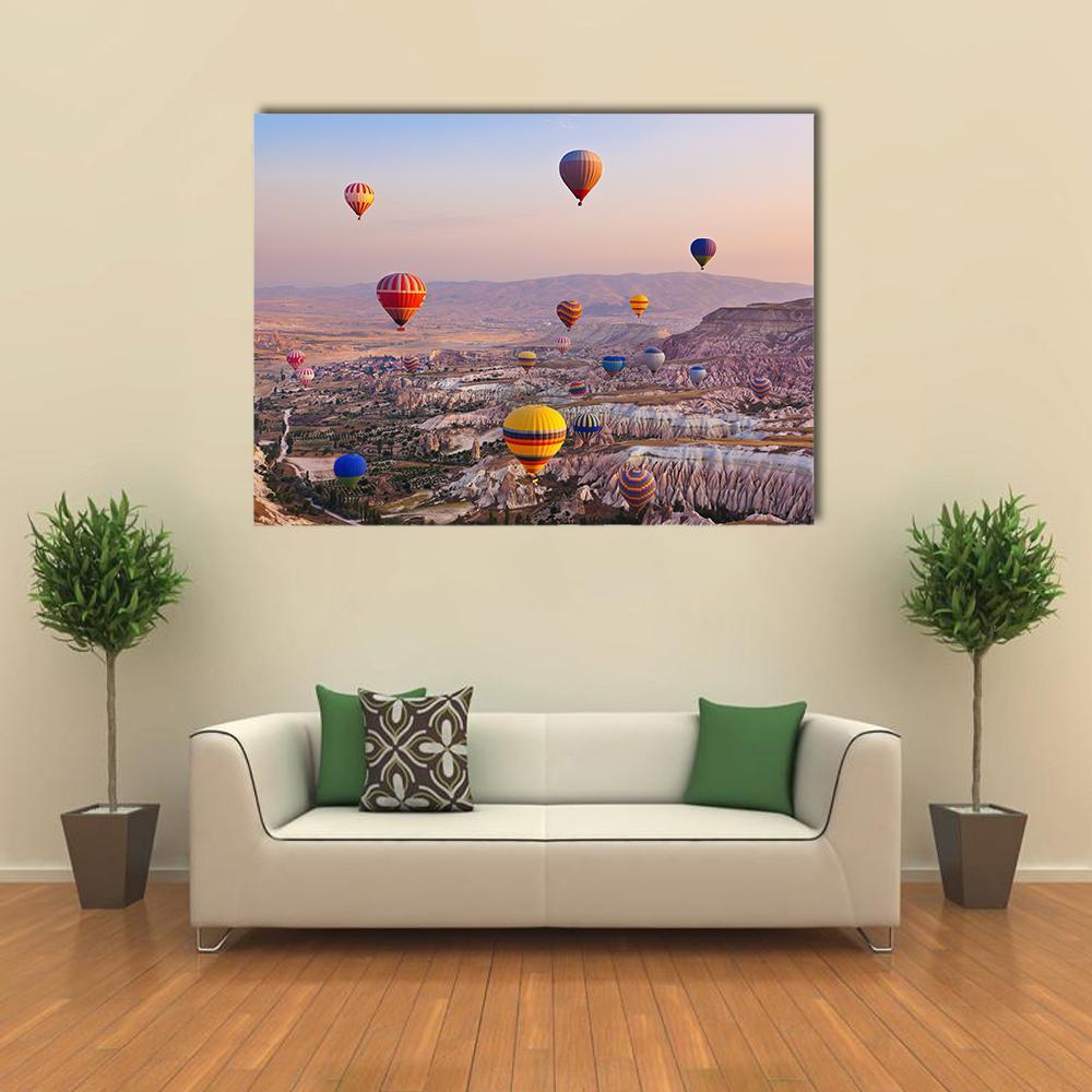 Hot Air Balloons Over Cappadocia Rocks Canvas Wall Art in beige, orange and blue, single panel hung on a wall