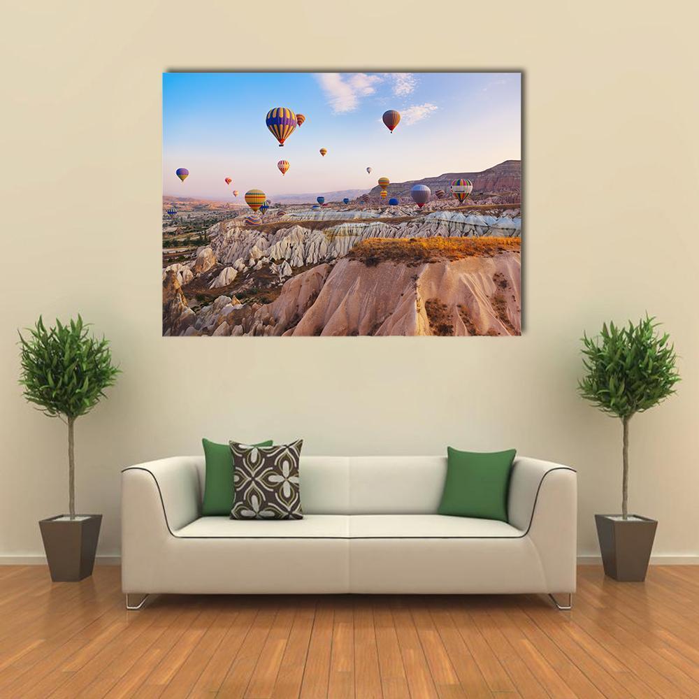 Hot Air Balloons Over Cappadocia Sunrise Canvas Wall Art in beige, orange and blue, single panel hung on a wall